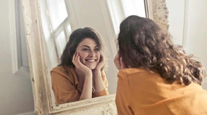 A confident woman admiring her reflection in a mirror, radiating joy and self-assurance.